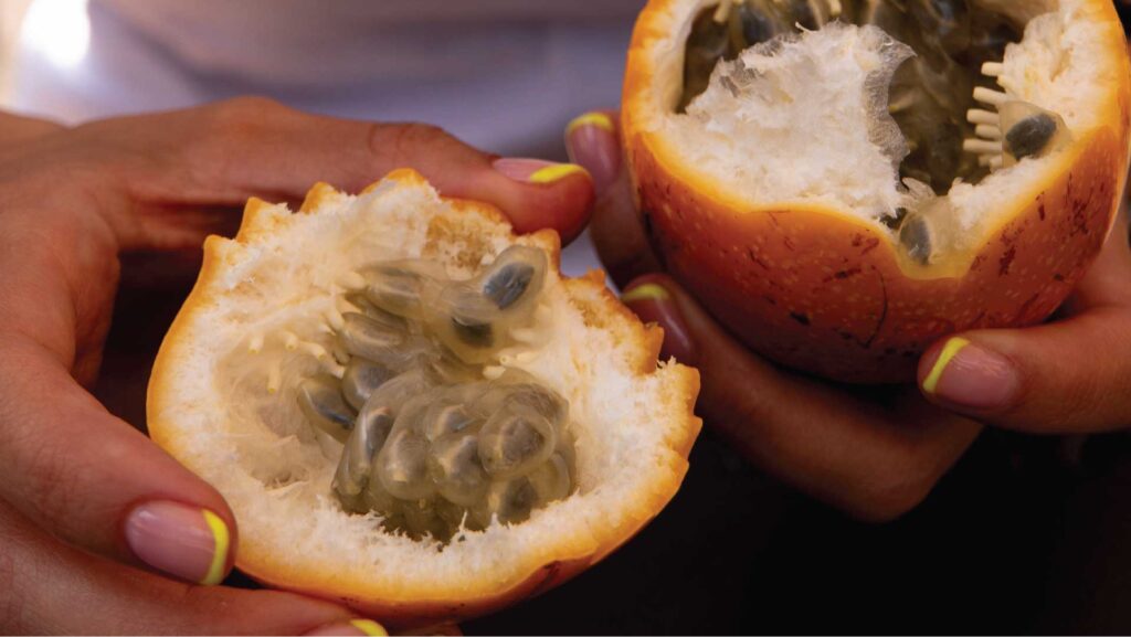 Opening a granadilla in Plaza de Mercado La Concordia, Bogota, Colombia